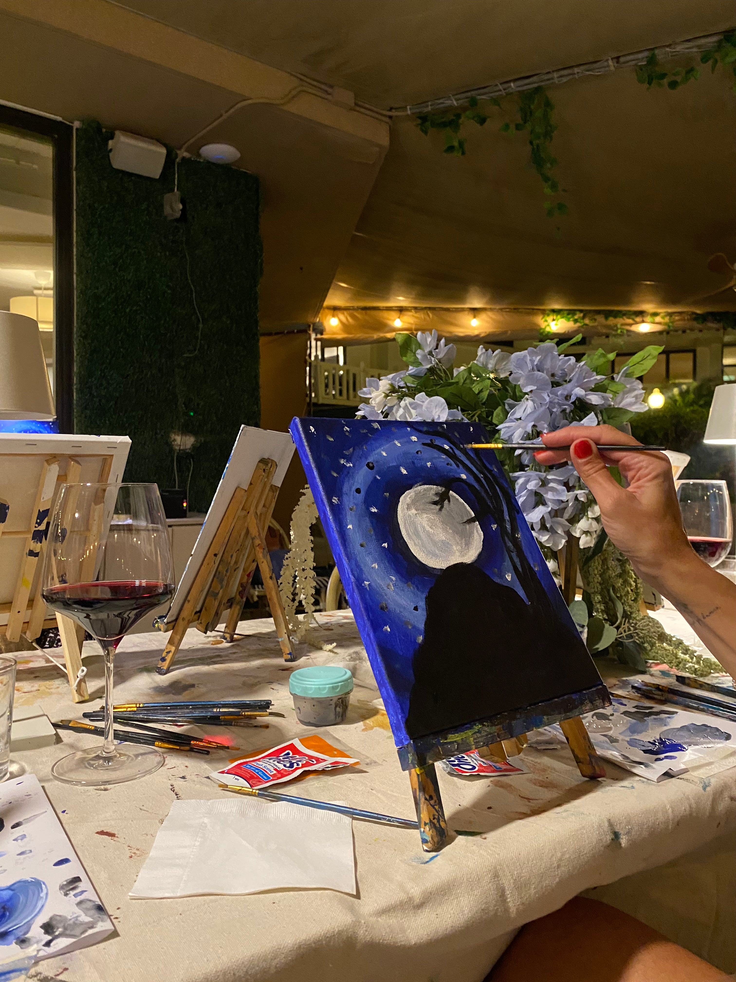 Students Acrylic painting of a full moon and mountain in blue black and white beautiful art class set up 